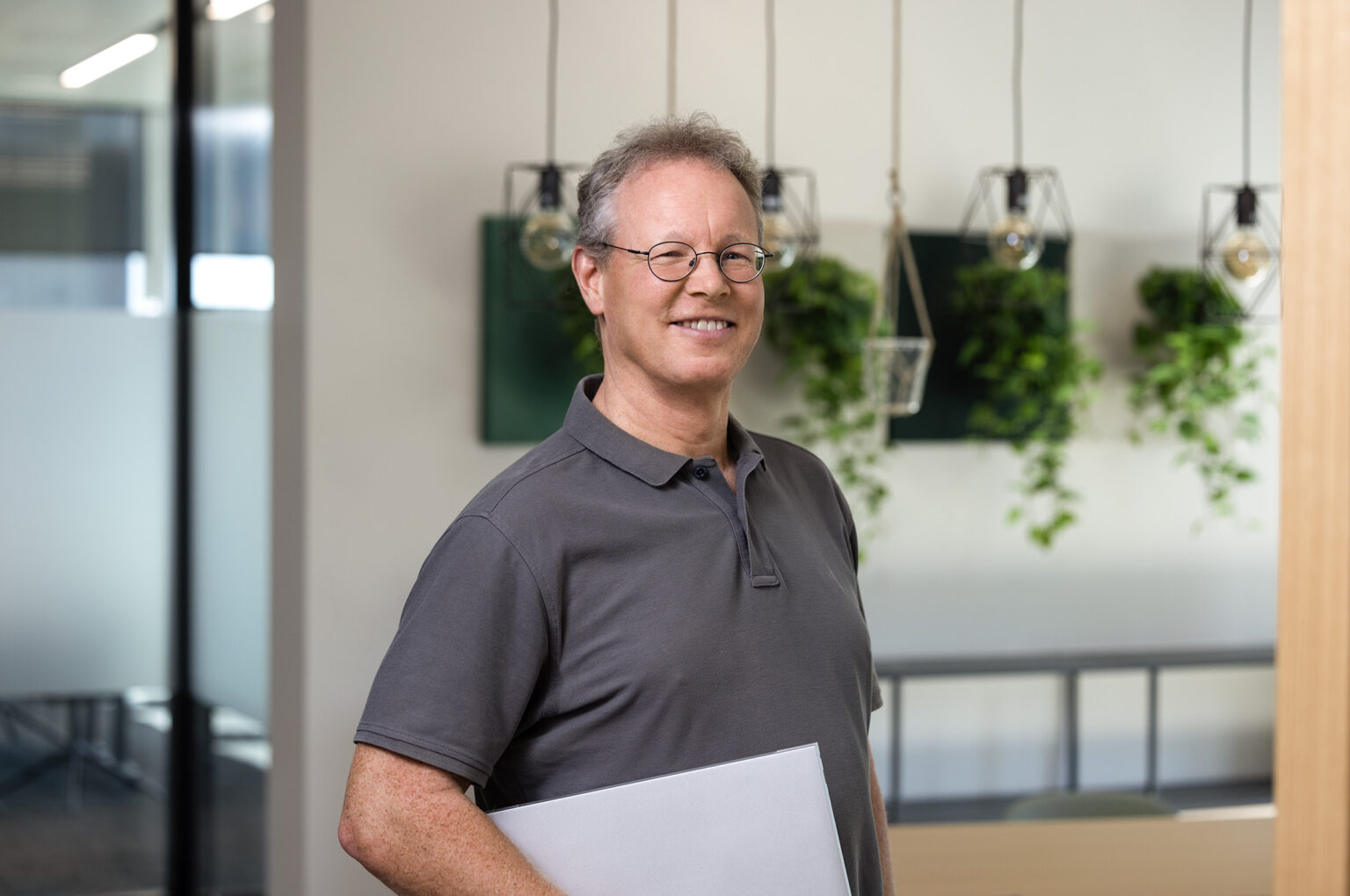 Teammitglied des Investitionsbereichs „Kleine Unternehmen“: Ein lächelnder Mann in einem modernen Büro.